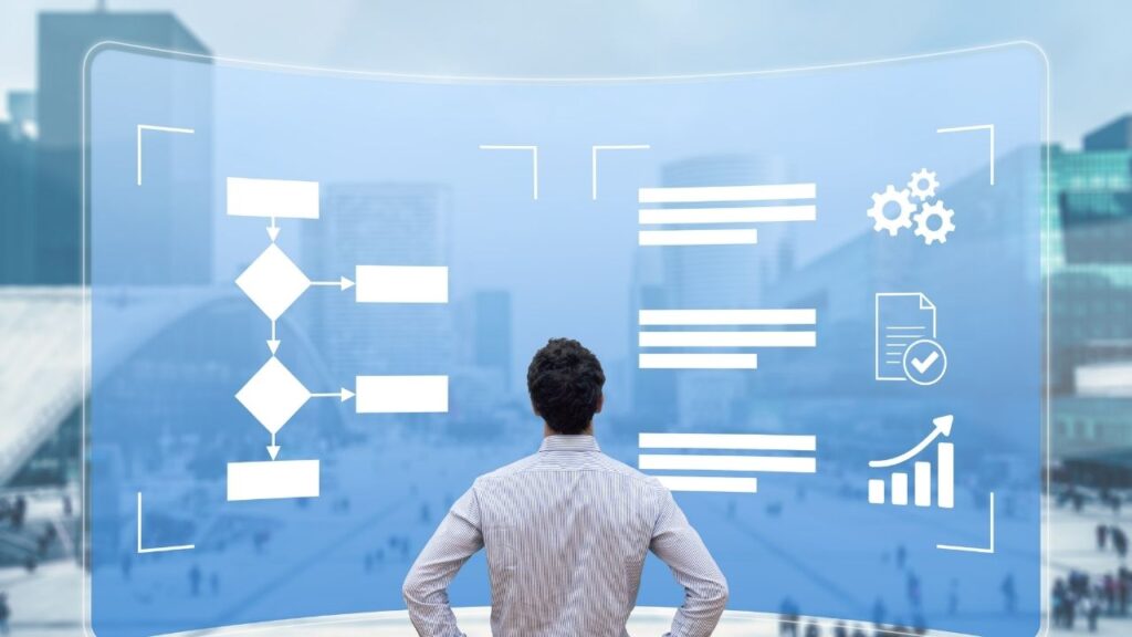 Homem olhando para uma tela com fluxogramas e gráficos relacionados a análise de processos.