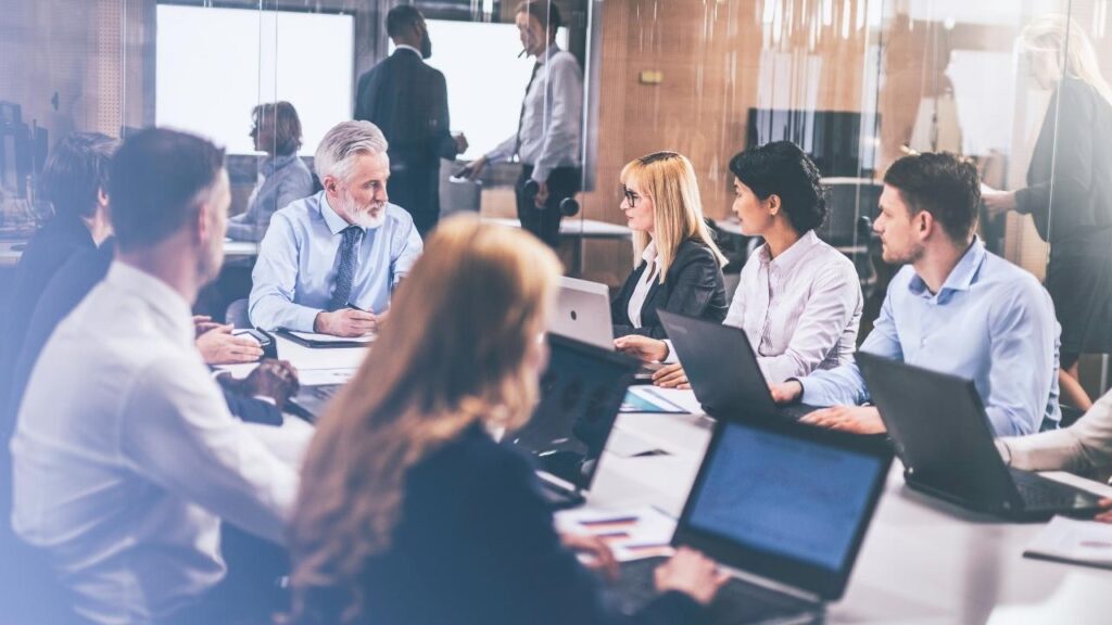 equipe corporativa em reunião com laptops em uma sala de conferências