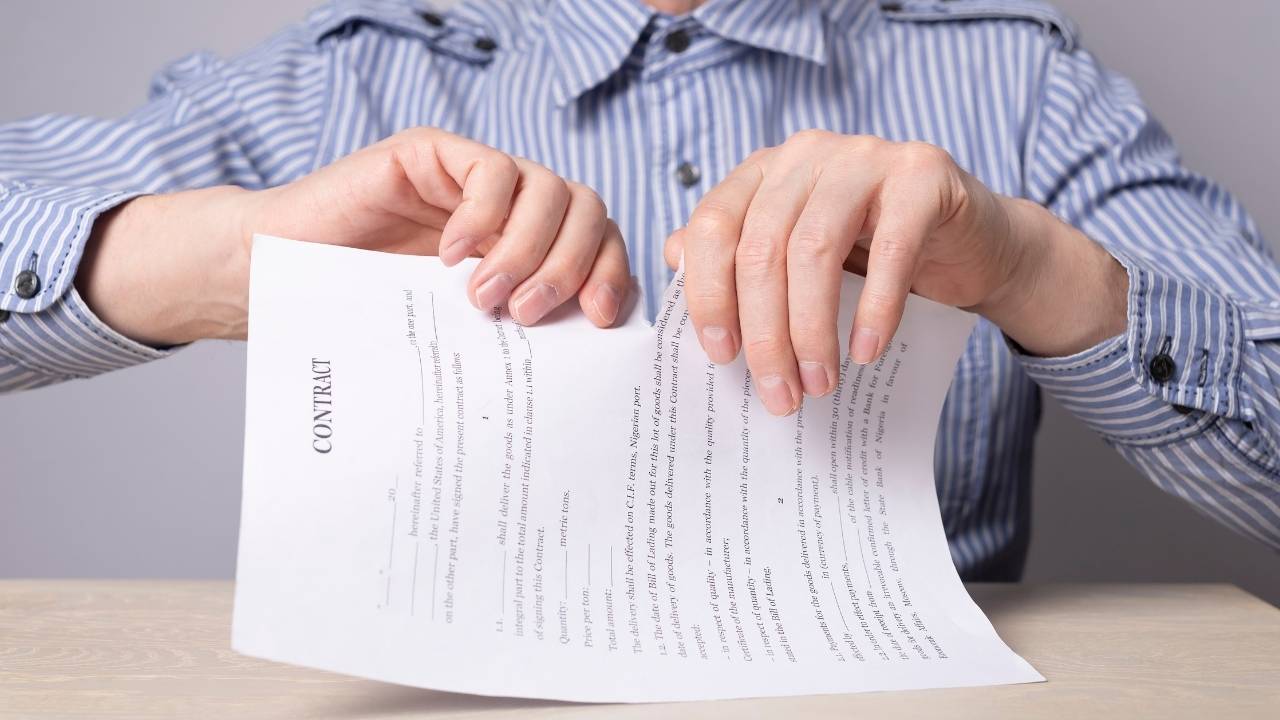 pessoa rasgando um contrato de trabalho.